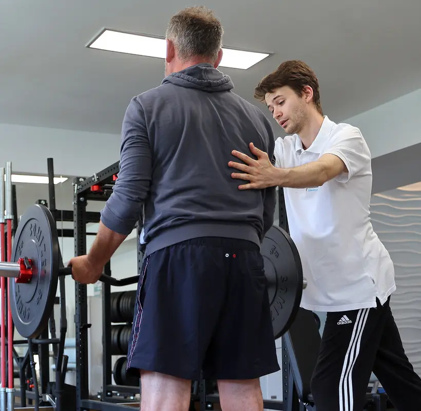 Muskelaufbautherapie mit Unterstüzung des Therapeuten, der die Haltung korrigiert im Römerbad Rottenburg